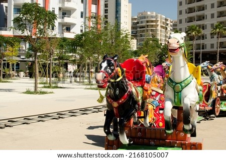 Children's carousel with two black and white horses in front. Albania. Vlore