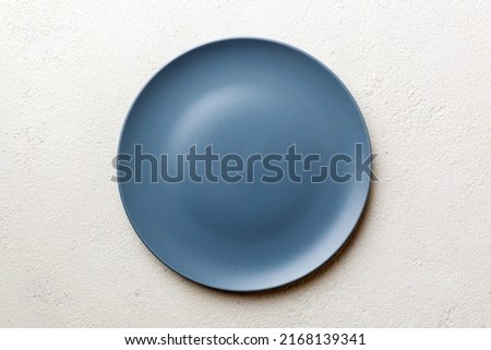 Top view of empty light plate on wooden background. Empty space for your design.