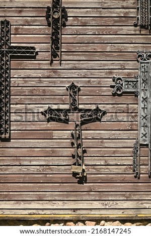 a fragment of a wooden wall with old metal crosses