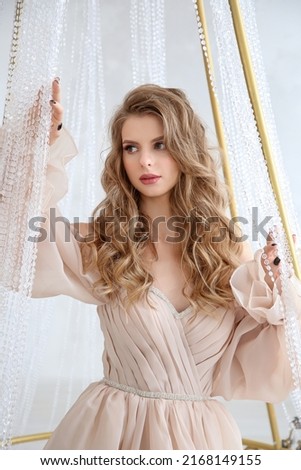 girl in a beautiful dress photo session in the studio with a chandelier
