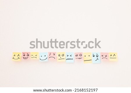 top view of paper cards with various smileys on white background