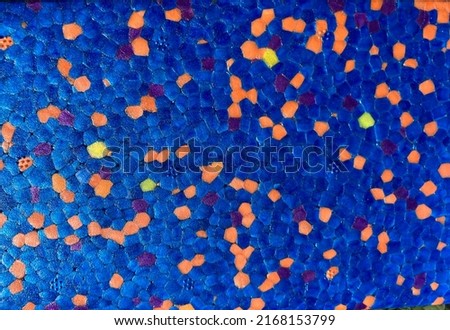 a blue, roughly pixelated surface with orange and yellow speckled dots