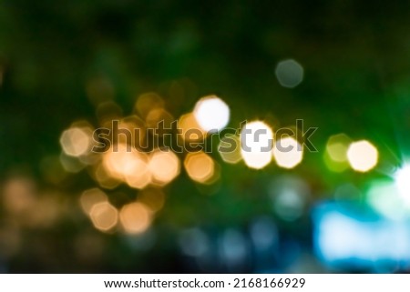 Dark background with lights with blur sparkling in orange, white, green and blue in foreground Royalty-Free Stock Photo #2168166929