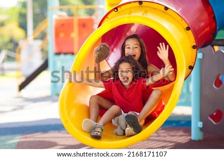 Kids on playground. Children play outdoor on school yard slide. Healthy activity. Summer vacation fun. Child playing in sunny park. Kid having fun on colorful slide. Royalty-Free Stock Photo #2168171107