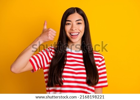 Photo of funky confident young woman dressed striped outfit showing thumb up isolated yellow color background
