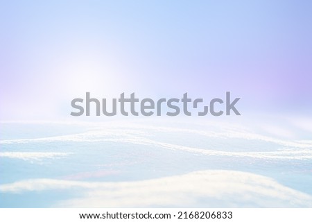SNOW ON COLD BLUE FROSTY BACKGROUND, BRIGHT WINTER BACKDROP WITH EMPTY PLACE ON SNOWY FIELD FOR MONTAGE PRODUCTS OR CHRISTMAS PRESENTS, NEW YEAR DESIGN Royalty-Free Stock Photo #2168206833
