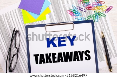 A notepad with the text KEY TAKEAWAYS, a pen, reports, bright stickers, paper clips and glasses lie on a white office table. Top view with copy space, flat lay.