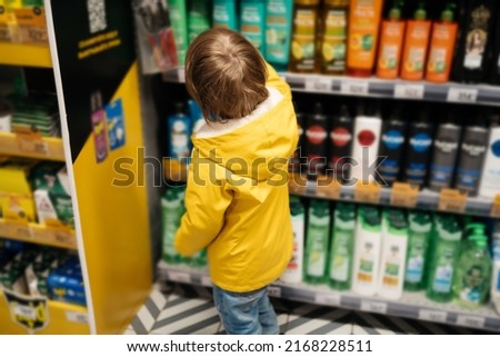 child in the market chooses a product, rear view