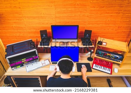 back of asian music producer working in home studio. music production concept