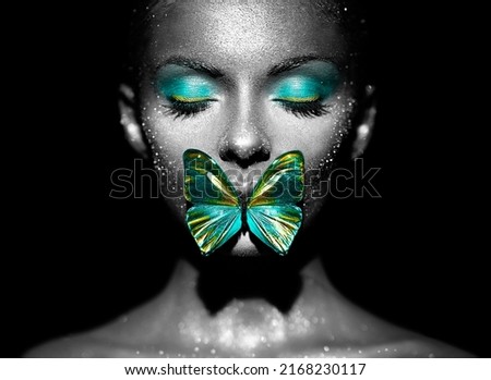 Fashion model woman in bright sparkles and lights posing in studio. Portrait of beautiful woman with butterfly. Art design glitter glowing make up. Black and white photography
