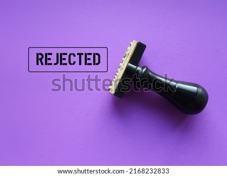 Rubber stamp with stamp words REJECTED on purple background, means refuse to agree to request, not given approval or acceptance to work or offer Royalty-Free Stock Photo #2168232833