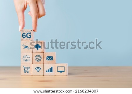 Hand putting wooden cube with 6G and technology icon, sixth generation internet technology which will change communication and lifestyle in the future. Royalty-Free Stock Photo #2168234807