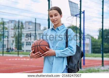 Portrait of teenage student girl with backpack and basketball ball