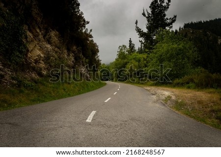 Desolate winding road in the mountains with lots of vegetation. Mountain road. Royalty-Free Stock Photo #2168248567