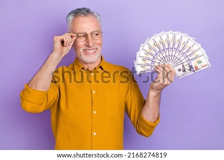 Photo of mature man hold cash rich profit salary earnings investment isolated over violet color background