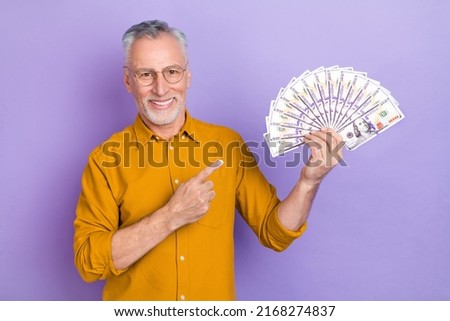 Photo of senior man indicate finger money benefit recommend promo isolated over violet color background