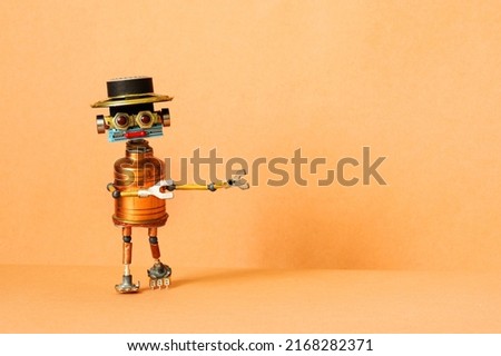 Creative design mechanical copper robot with a funny hat points his hands away from him. Peach color background. copy space for text.