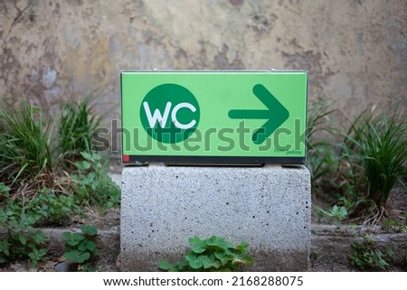 Direction arrow to the public toilet in the park.