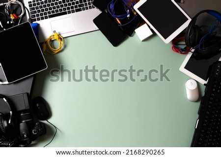 Top view to old laptop computers, digital tablets, mobile phones, many used electronic gadgets devices on green background. Planned obsolescence, electronic waste for recycling concept Royalty-Free Stock Photo #2168290265