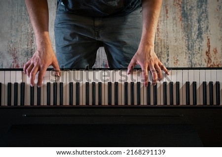 Male musician plays the piano, top view, hands.