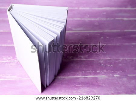 White book on wooden table, close-up
