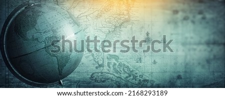 Ancient globe on the old map background. Selective focus. Retro style. Science, education, travel, vintage background. History and geography team. Blue tinted. Royalty-Free Stock Photo #2168293189