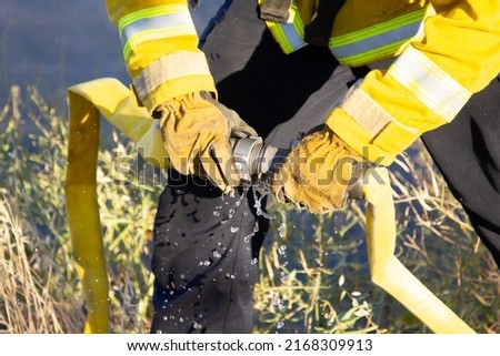 Gilroy, California June 15,2022: Gilroy and Cal Fire fire fighters connecting hose to help put out a grass fire Royalty-Free Stock Photo #2168309913