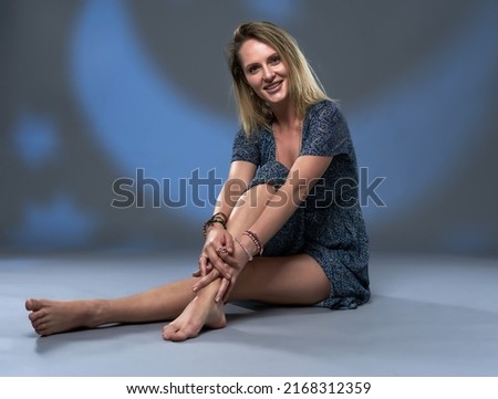 Studio beauty portrait of an attractive blonde woman in long dress