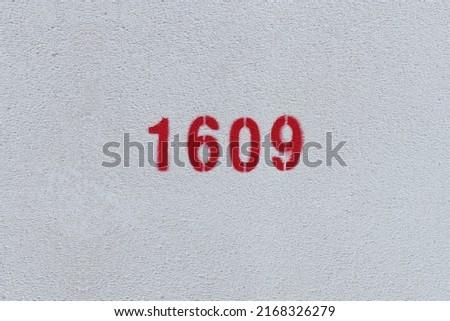Red Number 1609 on the white wall. Spray paint.
