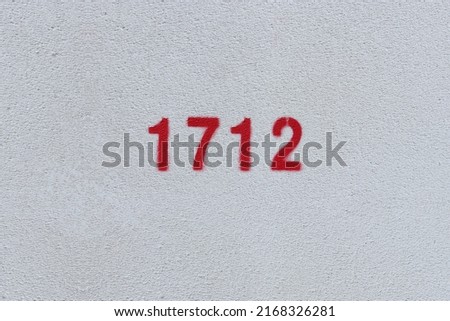 Red Number 1712 on the white wall. Spray paint.

