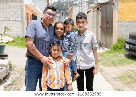 Latin family hugging outside their house in rural area - Happy Hispanic family in the village Royalty-Free Stock Photo #2168332985