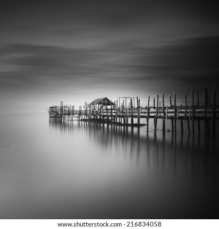 black and white image of "langgai" , the traditional fishing medium at Malaysia . Motion blur at the sky