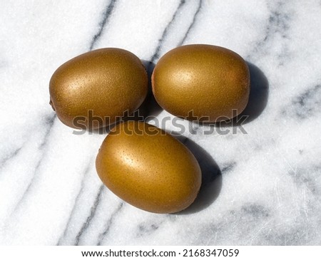 Group of golden kiwis on marble