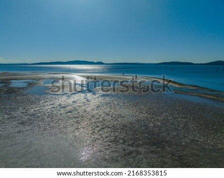 Sunlit sea water at Tilligerry Creek with boats and birds at Lemon Tree Passage, Port Stephens, NSW, Australia. Royalty-Free Stock Photo #2168353815