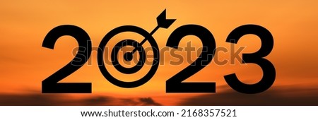 Concept Happy new year 2023 Silhouette image of website poster banner,  text 2023 and dartboard, success goal accomplished on beautiful sunrise background.