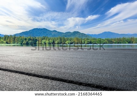 Asphalt road and mountain with lake natural scenery in Hangzhou, China.
