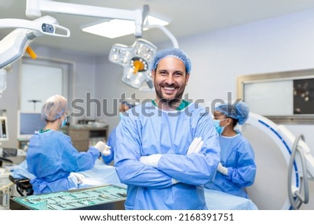 Portrait of male surgeon in operation theater looking at camera. Doctor in scrubs and medical mask in modern hospital operating room. Royalty-Free Stock Photo #2168391751