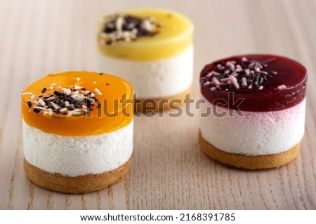 Three mini bavarois with fruits on wooden table Royalty-Free Stock Photo #2168391785