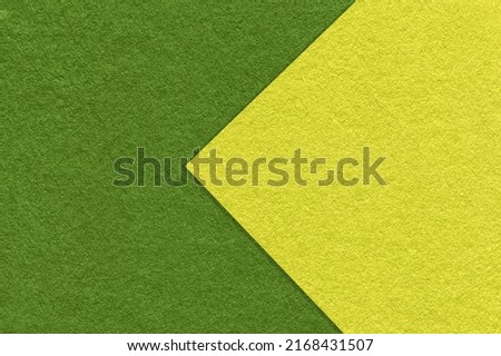 Texture of dark green and olive paper background, half two colors with arrow, macro. Structure of dense craft cardboard. Felt abstract backdrop closeup. Royalty-Free Stock Photo #2168431507