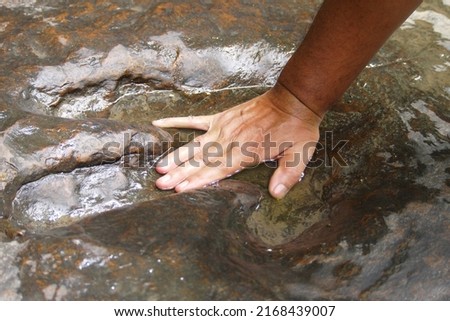 Human hands compared to dinosaur footprints,selective focus.
