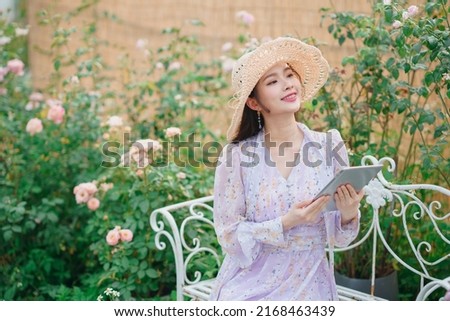 Fashion girl uses tablet computer in garden