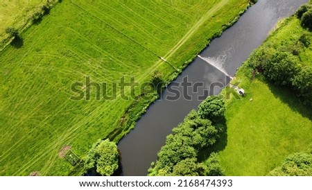 Aerial view looking down onto a  river surrounded by farmland. Taken in Whalley Lancashire England.  Royalty-Free Stock Photo #2168474393
