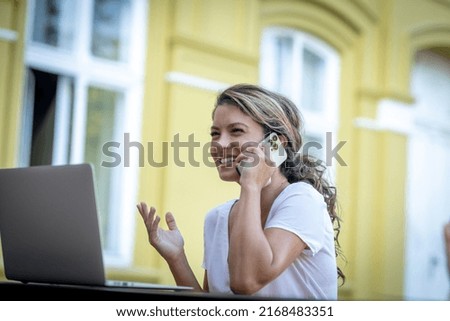 Business woman in outdoor caffe, having a call 