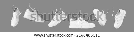 Flying white leather sneakers isolated on gray background. Fashionable stylish sports casual shoes. Creative minimalistic layout with footwear. Advertising for shoe store, blog Royalty-Free Stock Photo #2168485111
