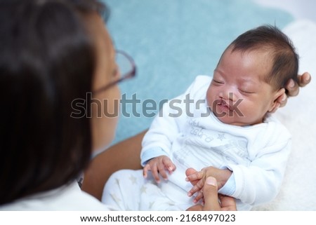 Finding comfort in the arms of her mother. Shot of a sleeping baby girl with a cleft palate being held by her mother. Royalty-Free Stock Photo #2168497023