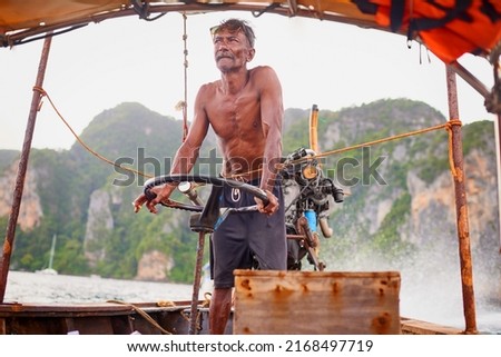Putting out to sea. Shot of a Thai man operating his tourist boat. Royalty-Free Stock Photo #2168497719