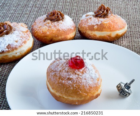 Fresh donuts and silver dreidel for Hanukkah celebration.
