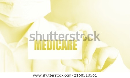 Doctor holding a card with Medicare, medical concept.