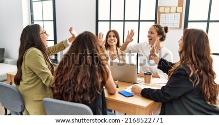 Group of businesswomen smiling happy celebrating high five at the office. Royalty-Free Stock Photo #2168522771