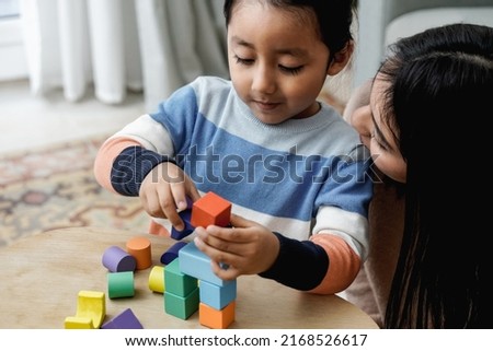 Latin American mother and son having fun playing with toy bricks at home - Family love concept - Focus on kid face Royalty-Free Stock Photo #2168526617
